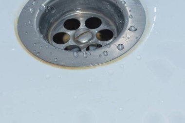 Lavaboda drenaj deliği var. Beyaz bir lavaboya düşer. Lavabodaki metal drenaj.