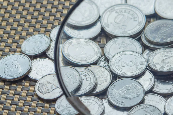 Büyüteçle etrafa saçılmış bozuk paralar. Finansal sorunlar. Ukrayna 'da para yok.