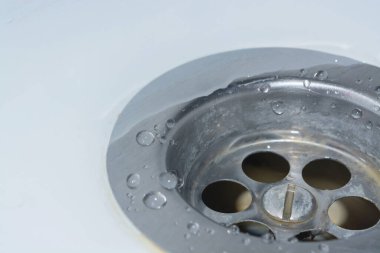 Suyu lavabodaki deliğe boşaltıyorum. Banyoda beyaz lavabo. Metal lavabo deliği