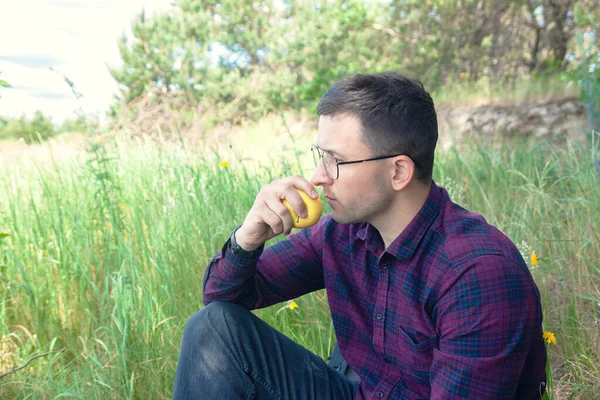 Young Man Sits Forest Eats Apple Rest Open Air Nice — Stock Photo, Image