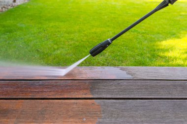 Tahta teras yüzeyinde yüksek su basıncı temizleyicisi olan elektrikli süpürgeyle temizlik terası sığ alan derinliği