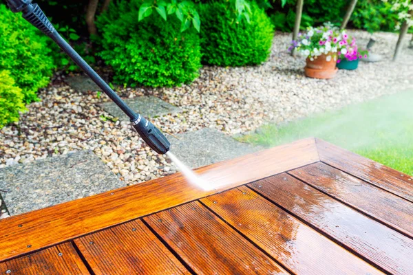 Tahta teras yüzeyinde yüksek su basıncı temizleyicisi olan elektrikli süpürgeyle temizlik terası sığ alan derinliği