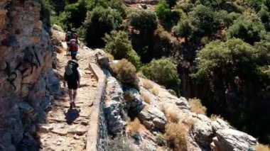 Sırt çantalı bir grup turist, Türkiye 'nin Akdeniz kıyısındaki Lycian Patikası boyunca ilerliyorlar. Yürüyüş, seyahat, yürüyüş yapan grup insanlarının hava görüntüsü.
