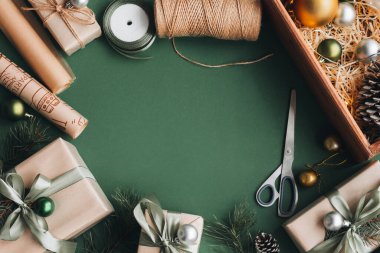 Yaratıcı hobi. Bir kadının elleri, el yapımı el yapımı Noel hediyesini sicim kurdelesiyle sarar. Noel hediye kutusunda fiyonk yapmak, beyaz ahşap masada kar taneleriyle süslenmek, üst manzara.