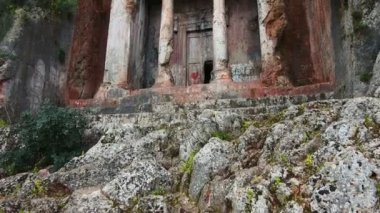 Türkiye 'nin Fethiye kentindeki Lycian mezarları. Amintas 'ın mezarları şehrin üzerinde yükselen kayalara oyulmuş, ve uzaktan şehrin ve dağların manzarası.
