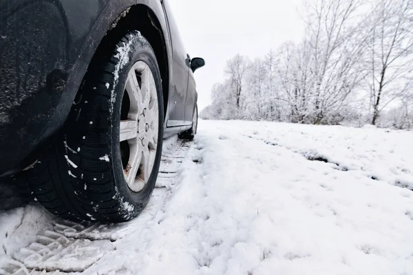 stock image Winter tire. Car on snow road. Tires on snowy highway detail.