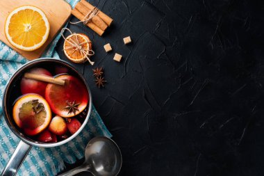 Evde sıcak şarap yapıyorum. Masanın üzerinde, yanında tarçın, narenciye, kurutulmuş portakal, yıldız anason, kamış şekeri var..