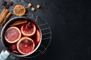 Evde sıcak şarap yapıyorum. Masanın üzerinde, yanında tarçın, narenciye, kurutulmuş portakal, yıldız anason, kamış şekeri var..