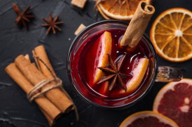 Evde sıcak şarap yapıyorum. Masanın üzerinde, yanında tarçın, narenciye, kurutulmuş portakal, yıldız anason, kamış şekeri var..