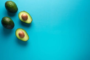 Mavi arka planda taze avokadolar. Yazı için boş yeri olan pankart. Sağlıklı Yeme.