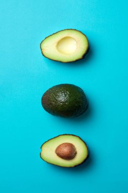 Mavi arka planda taze avokadolar. Yazı için boş yeri olan pankart. Sağlıklı Yeme.
