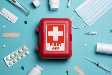 Home first aid kit on a blue background. The elements of the first aid kit