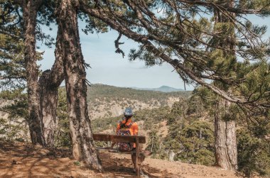 Girl sitting on the bench in Troodos mountain, Cyprus