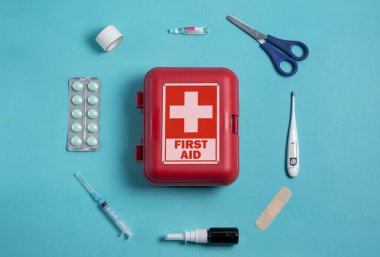 Home first aid kit on a blue background. The elements of the first aid kit