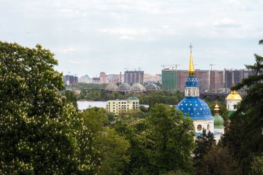 Botanik bahçesinden Kyiv şehrinin sol kıyısında çiçek açan leylak manzarası. Yüksek binalara odaklan