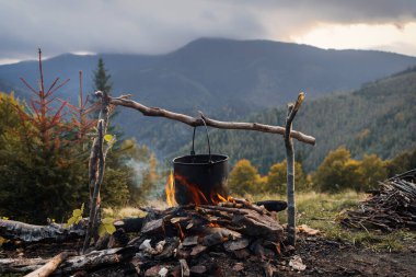 Dağlarda kamp ateşinde yemek pişirmek. Kamp sezonu. Çadırlar içinde dağlarda dolaşırlar..