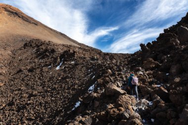 Turistler Teide volkanına tırmanır. Lav alanları boyunca yol.