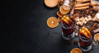 Mulled wine is the main drink of Christmas markets on a dark background. Christmas banner. clipart