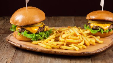 Tahta masada patates kızartmalı lezzetli bir hamburger.