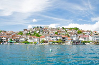 Gölden çok güzel bir manzara. Kayıklar, taşlar, kumsal, açık mavi gökyüzü.