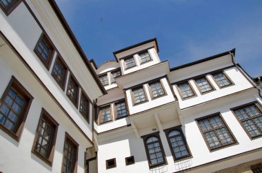 Terk edilmiş beyaz eski ev tarzı. Açık mavi gökyüzünde ahşap pencereleri var. 