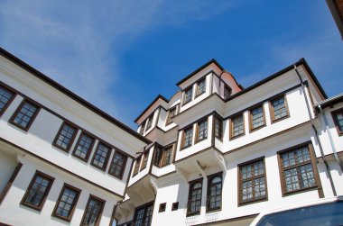 Terk edilmiş beyaz eski ev tarzı. Açık mavi gökyüzünde ahşap pencereleri var. 