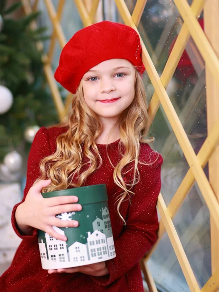 선물과 창문에 빨간색에 금발의 크리스마스 유리를 바라보는 — 스톡 사진