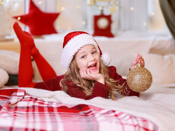 Loira Menina Vermelho Deitado Cama Com Natal Bauble Mão — Fotografia de Stock