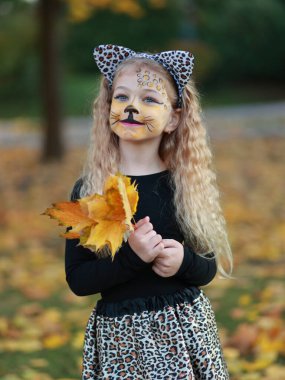 Küçük kız Cadılar Bayramı 'nı parkta kutluyor.