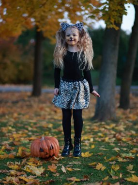 Küçük kız Cadılar Bayramı 'nı parkta kutluyor.
