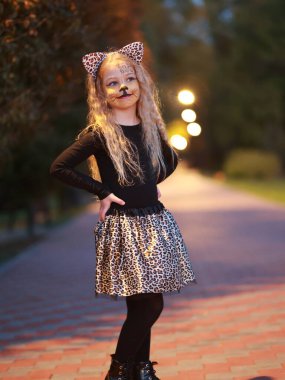 Küçük kız Cadılar Bayramı 'nı parkta kutluyor.