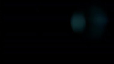 Geçiş ve kaplama efektleri için mavi sızıntılı ışık demeti ve bokeh röfleleri siyah arkaplanda sağa hareket ediyor.