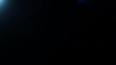 Işık demeti mavi ışık sızıntısı ile doğal geçiş parlayan altıgen bokeh soldan sağa siyah üzerine hareket ederek kaplama etkisi, 4k