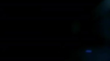 Mavi mercek parlıyor. Kaplama için siyah arkaplanda çerçevenin sağındaki Cyan renk ışık sızıntısı.