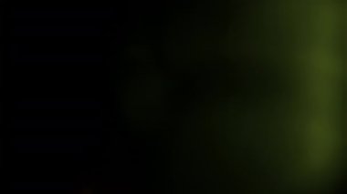 Sarı ışık sızıntılı geçiş ışını sağdan sola hareket ediyor, siyah arkaplanda bokeh renkleriyle.