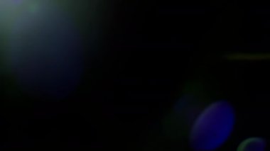 Parlak ışık çerçevenin üstünden sağa hareket eder, ışık lense sızar, ışık geçişleri için siyah arkaplan üzerinde halo, bokeh röfleleri ve difüzyon yaratır ve efektler oluşturur.