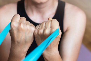 Kadın, direniş bandıyla pazılar için egzersiz yapıyor..