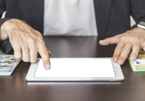 Person using digital tablet on work desk touching blank screen with finger.