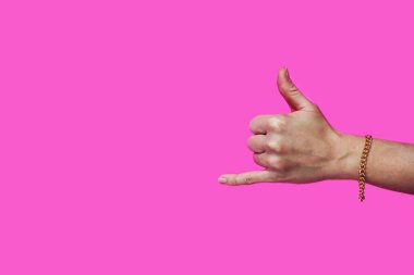 El hareketi Pembe arka planda Shaka işareti, bileğinde altın zincir.