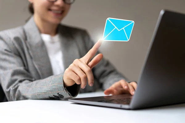 Young businesswoman opening virtual email with touching her finger to digital mail envelope.