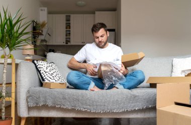 Posta paketini açan adam, çevre dostu paket değil..