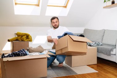 Gönüllü adam eski kıyafetlerini evde karton kutulara doldurup, ikinci el konseptini yeniden kullanıyor..