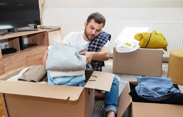 Man packing his clothes, moving house concept