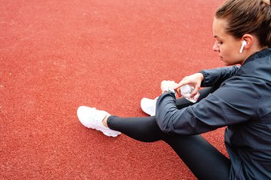 Spor yaptıktan sonra dijital saatini kullanan bayan sporcu..