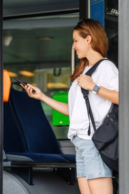 Şehirdeki toplu taşımacılığın genç yolcusu cep telefonuyla troleybüs seyahatinin parasını ödüyor..