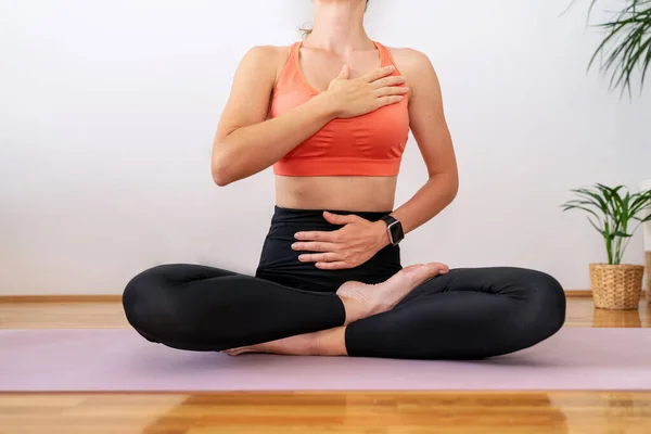 Meditasyon nefes egzersizi. Spor kıyafetleri giyen kadın lotus yogası pozu verip meditasyon yapıyor..