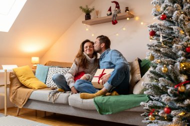 Erkekler kadınlara Noel hediyesi verir. Erkek arkadaşı kız arkadaşına Noel hediyesi verir ve onu yanağından öper.. 