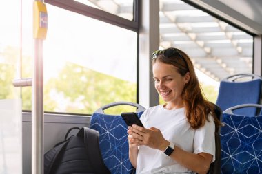 Şehir toplu taşıma yaşam tarzı. Servis otobüsüyle seyahat ederken akıllı telefonunu kullanan bir kadın..