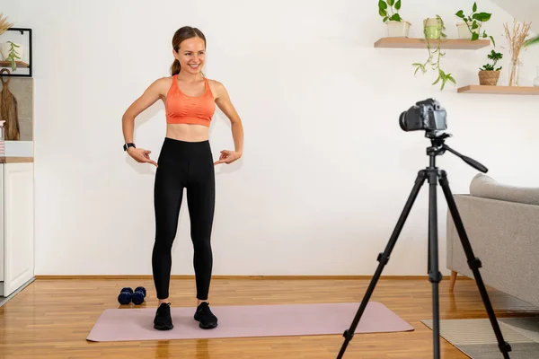 Online fitness training. Fitness instructor recording video of workout for her subscribers.