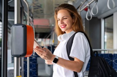 Şehrin kadın yolcusu akıllı telefonuyla toplu taşıma otobüsüne ödeme yapıyor..